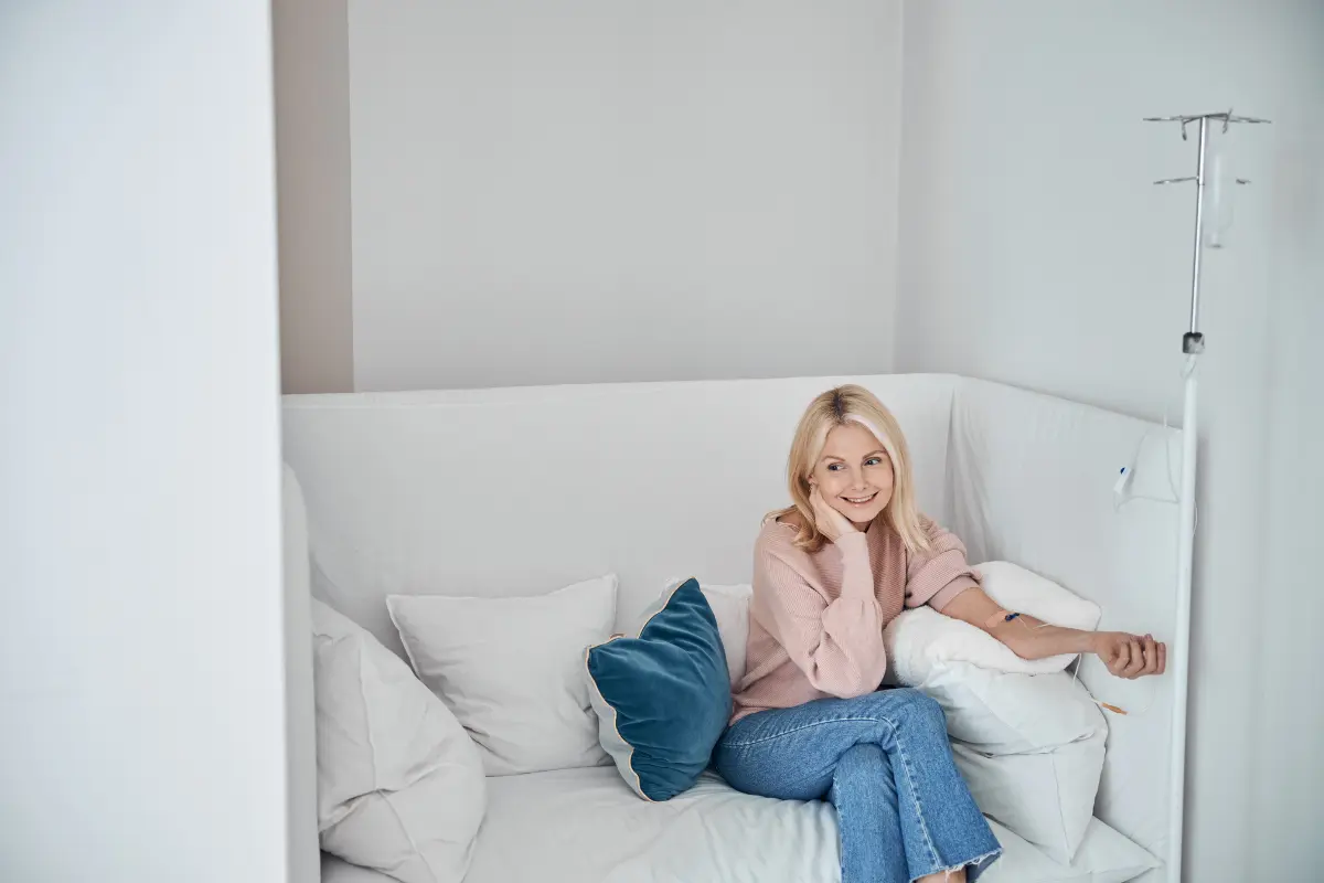 Woman receiving IV Therapy while relaxing on a sofa in Farmingville, NY